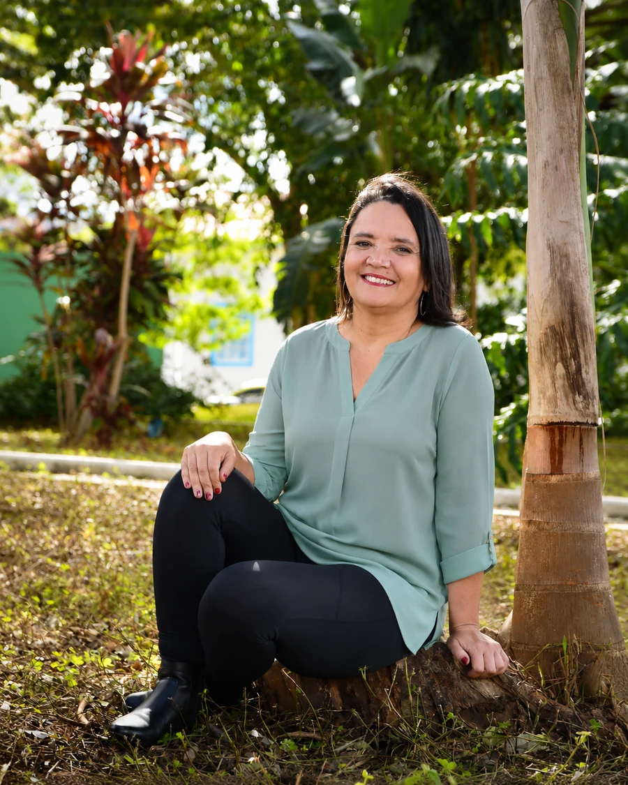 Neide Braz, terapeuta corporal e criadora do método VitalSoma®, sentada em meio à natureza